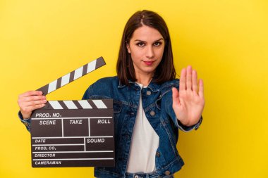 Sarı arka planda izole edilmiş, elini uzatarak dur işareti gösteren, seni engelleyen beyaz bir kadın var..