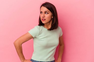 Pembe arka planda soyutlanmış beyaz bir kadın. Gülümsüyor, neşeli ve keyifli görünüyor..