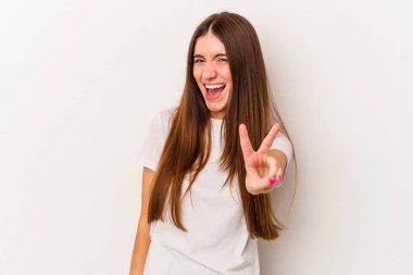 Beyaz arka planda izole edilmiş genç beyaz kadın iki numarayı parmaklarıyla gösteriyor..