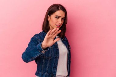 Pembe arka planda izole edilmiş genç beyaz kadın yakın bir tehlike nedeniyle şoka uğruyor.