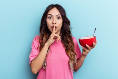 Melez bir kadın elinde mısır gevreği kasesi tutarken mavi arka planda bir sır saklıyor ya da sessizlik istiyor..