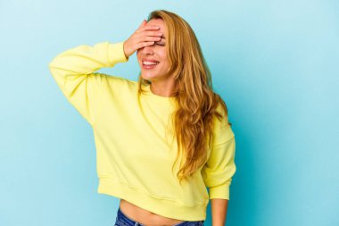 Mavi arka planda soyutlanmış beyaz bir kadın elleriyle gözlerini kapatıyor, gülümseyerek bir sürpriz bekliyor..