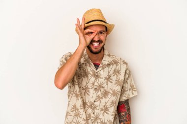 Beyaz arka planda izole edilmiş yaz kıyafetleri giyen beyaz, dövmeli genç bir adam heyecanlı..