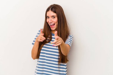 Beyaz arka planda izole edilmiş genç beyaz kadın parmaklarıyla ön tarafı işaret ediyor..