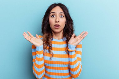 Mavi arka planda izole edilmiş genç Meksikalı kadın şaşırdı ve şok oldu..
