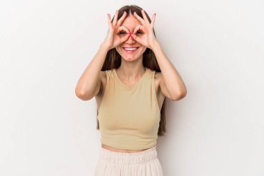 Beyaz arka planda izole edilmiş beyaz tenli genç bir kadın gözlerinde sorun olmadığını gösteriyor.