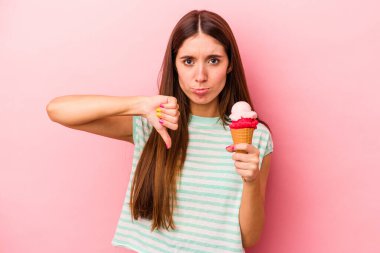Elinde dondurma tutan beyaz bir kadın pembe arka planda izole edilmiş, hoş olmayan bir jest gösteriyor. Anlaşmazlık konsepti.