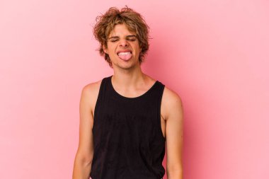 Makyajlı beyaz bir adam pembe arka planda izole edilmiş komik ve dostane bir dille konuşuyor..