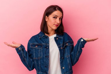 Pembe arka planda soyutlanmış beyaz bir kadın. Kafası karışmış ve omuz silkiyor. Kopya alanını tutmak için..