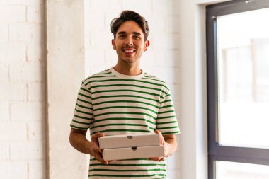 Genç melez yarışçı pizza topluyor.