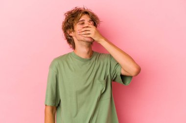 Pembe arka planda soyutlanmış, gülen, kaygısız, doğal duyguları olan beyaz bir genç..