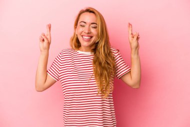 Kafkasyalı sarışın kadın pembe arka planda izole edilmiş şans dilemek için şans diliyor.