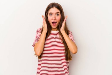 Beyaz arka planda izole edilmiş genç beyaz kadın şaşırmış ve şok olmuş..