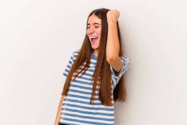 Beyaz arka planda izole edilmiş genç beyaz kadın zaferi, tutkuyu ve coşkuyu kutluyor, mutlu bir ifade..