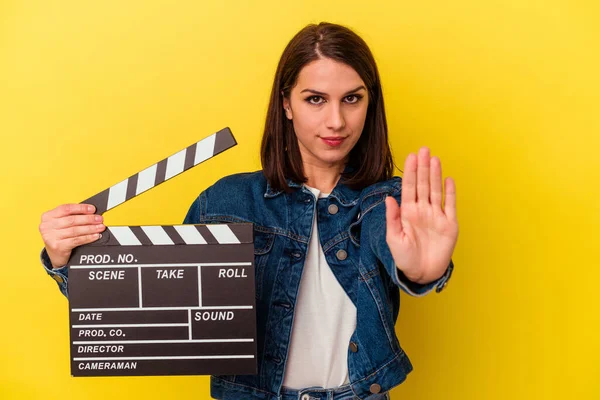 Sarı arka planda izole edilmiş, elini uzatarak dur işareti gösteren, seni engelleyen beyaz bir kadın var..