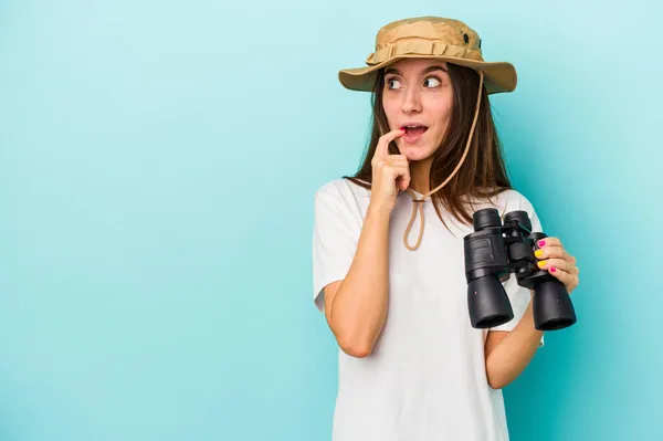 Junge Kaukasische Entdeckerfrau Mit Fernglas Isoliert Auf Blauem Hintergrund Denkt — Stockfoto