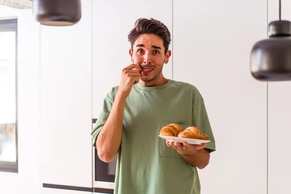 Joven Hombre Raza Mixta Comiendo Croissant Una Cocina Mañana Mordiendo — Foto de Stock
