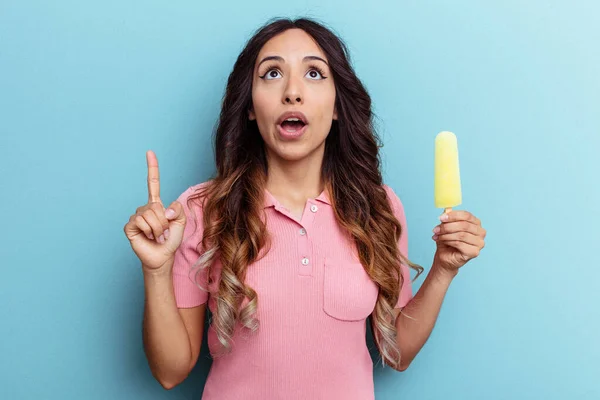 Mujer Latina Joven Sosteniendo Helado Aislado Sobre Fondo Azul Apuntando — Foto de Stock