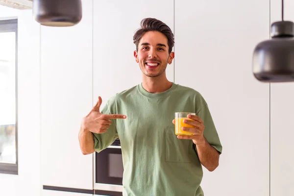 Joven Hombre Raza Mixta Bebiendo Jugo Naranja Cocina Persona Señalando — Foto de Stock