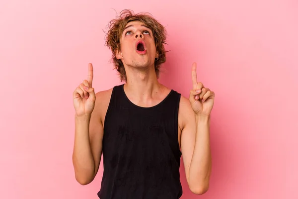 Jonge Blanke Man Met Make Geïsoleerd Roze Achtergrond Wijzen Ondersteboven — Stockfoto