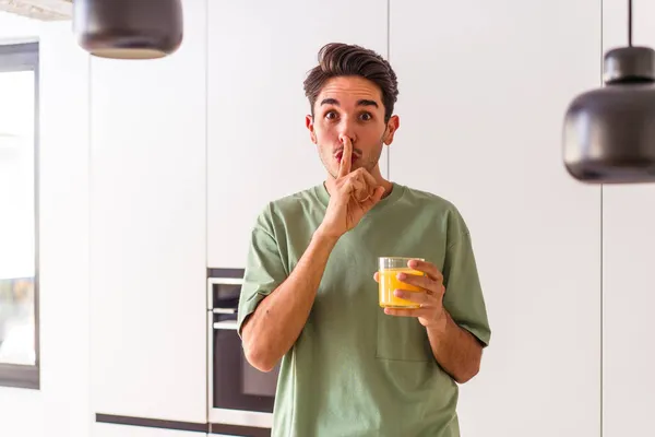 Joven Mestizo Bebiendo Jugo Naranja Cocina Guardando Secreto Pidiendo Silencio — Foto de Stock