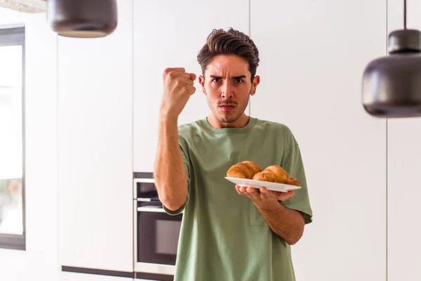 Joven Hombre Raza Mixta Comiendo Croissant Una Cocina Mañana Mostrando — Foto de Stock