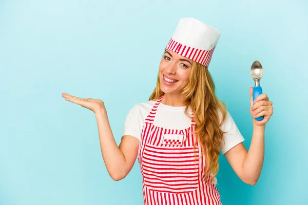青い背景に隔離されたアイスクリームスクープを持つ白人のアイスクリームメーカーの女性は 手のひらにコピースペースを示し 腰に別の手を保持 — ストック写真