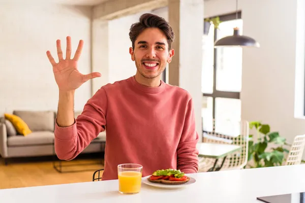 Joven Hombre Raza Mixta Desayunando Cocina Sonriendo Alegre Mostrando Número — Foto de Stock