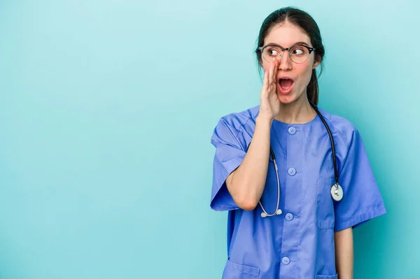 Jovem Enfermeira Caucasiana Isolado Fundo Azul Está Dizendo Segredo Quente — Fotografia de Stock