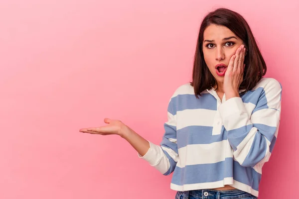 Joven Mujer Caucásica Aislada Sobre Fondo Rosa Impresionado Sosteniendo Espacio —  Fotos de Stock