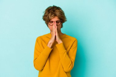 Mavi arka planda soyutlanmış beyaz makyajlı genç bir adam. Dua ediyor, bağlılık gösteriyor. İlahi ilhamı arayan dindar biri..