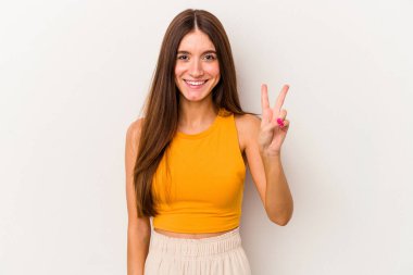 Beyaz arka planda izole edilmiş genç beyaz kadın iki numarayı parmaklarıyla gösteriyor..