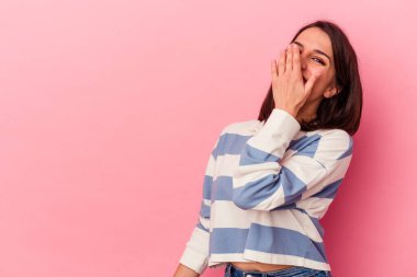 Pembe arka planda soyutlanmış genç beyaz kadın gülüyor, kaygısız, doğal duygu..