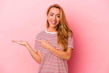 Kafkasyalı sarışın kadın pembe arka planda izole edilmiş. Elinde bir fotokopi odası olduğu için heyecanlı..