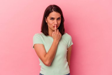 Genç, beyaz bir kadın pembe arka planda izole edilmiş düşünüyor ve yukarı bakıyor, yansıtıyor, düşünüyor, fantezi kuruyor..