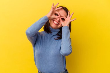 Sarı arka planda izole edilmiş genç beyaz kadın gözlerinde sorun olmadığını gösteriyor.