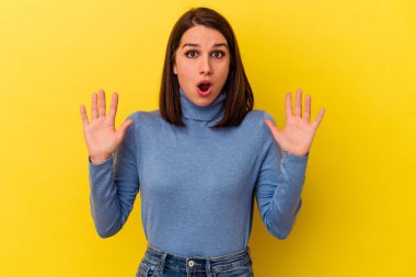 Sarı arka planda izole edilmiş genç beyaz bir kadının bir fikri var, ilham verici bir kavram..