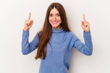 Beyaz arka planda izole edilmiş genç beyaz kadın iki parmağı da boş bir alan gösteriyor..