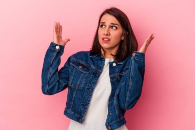 Pembe arka planda izole edilmiş genç beyaz kadın gökyüzüne haykırıyor, yukarı bakıyor, hayal kırıklığına uğramış..