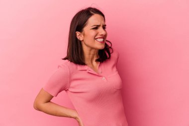 Pembe arka planda izole edilmiş beyaz bir kadın sırt ağrısı çekiyor..