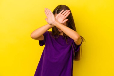 Sarı arka planda izole edilmiş genç beyaz kadın iki kolu çapraz tutuyor, inkar kavramı.