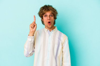 Mavi arka planda soyutlanmış beyaz makyajlı genç bir adamın harika bir fikri var, yaratıcılık kavramı..