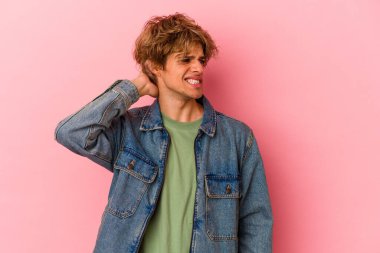 Pembe arka planda soyutlanmış beyaz makyajlı genç bir adam yorgun ve çok uykulu..