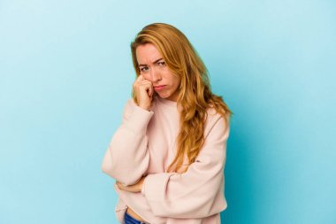 Beyaz kadın mavi arka planda izole edilmiş. Tekrarlanan bir görevden yorulmuş..