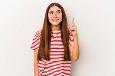 Beyaz arka planda izole edilmiş genç beyaz kadın iki parmağı da boş bir alan gösteriyor..