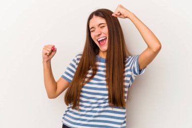 Beyaz arka planda izole genç beyaz kadın zafer kazandıktan sonra yumruğunu kaldırıyor, kazanan konsept..