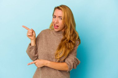 Mavi arka planda izole edilmiş beyaz bir kadın işaret parmaklarıyla fotokopi alanını işaret ederek heyecan ve arzusunu ifade ediyor..