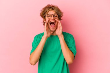 Makyajlı beyaz bir adam pembe arka planda izole edilmiş. Dedikodu yapıyor, bir şeyleri bildiriyor..