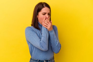 Sarı arka planda izole edilmiş genç beyaz kadın virüs ya da enfeksiyon yüzünden boğazında ağrı hissediyor..