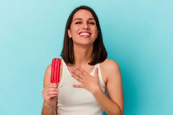 青い背景で隔離されたアイスクリームを持っている若い白人女性は大声で手を胸に保つことを笑う — ストック写真